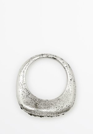 Metallic sølv ring med en glat, tekstureret overflade. Rund form med en bred ring og et åbent centrum, der har subtile variationer i finish.