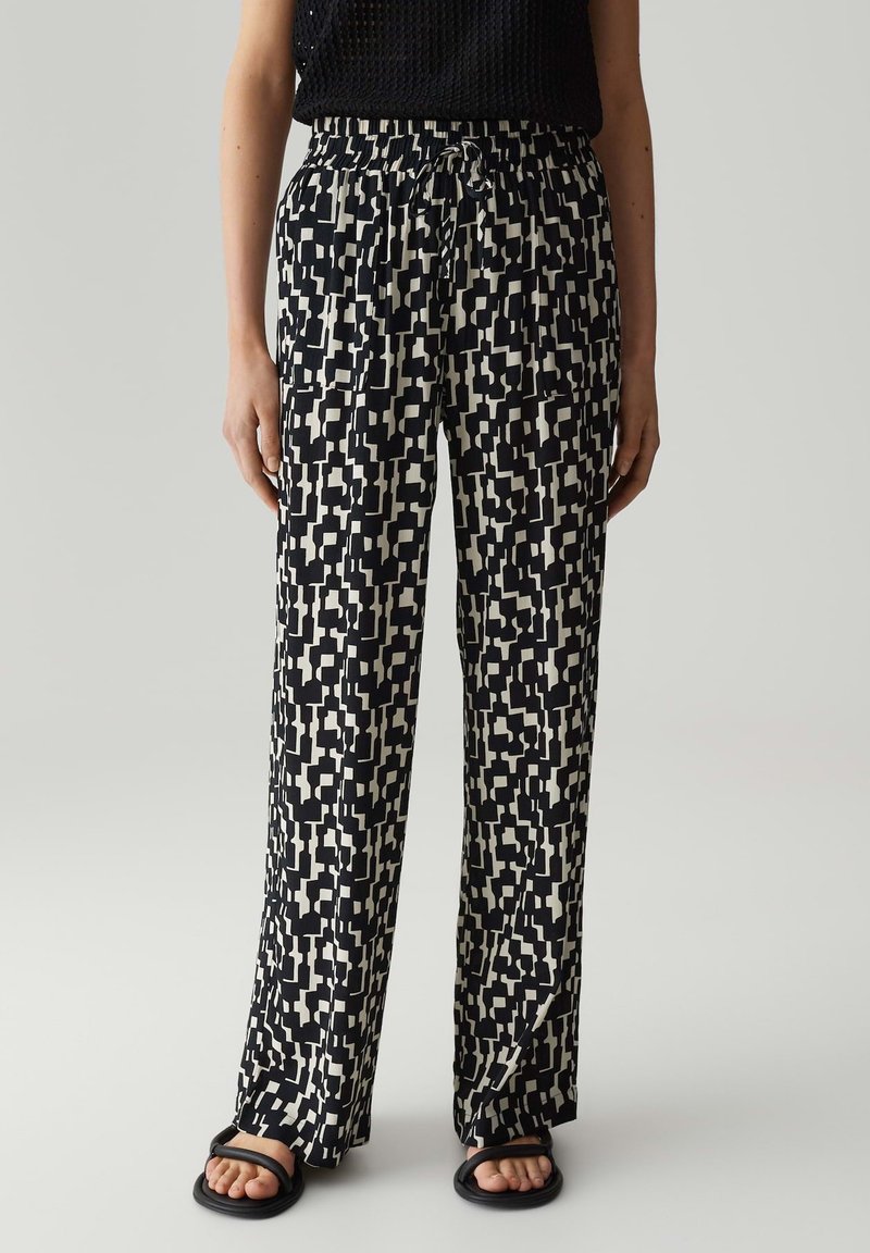 Zwarte en beige gestreepte wijde broek met een elastische tailleband. Lichtgewicht stof met een geometrisch ontwerp, biedt een losse pasvorm en comfort.