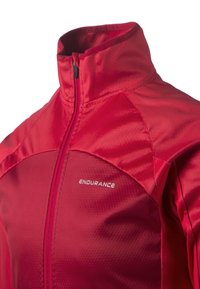 Röd sportjacka i ett mjukt, lätt material. Har en hög krage och hel dragkedja, med en logotyp på bröstet och ett texturerat mönster.