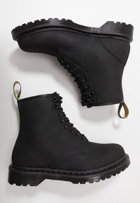 Zwarte enkellaarsjes gemaakt van een gestructureerd materiaal met een vetersluiting aan de voorkant, een ronde neus en een robuuste rubberen zool. Voorzien van een trekkoordje aan de hiel.