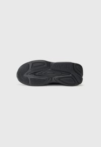 Black rubber sneaker sole with textured grip patterns and raised accents, featuring a prominent logo and contoured design elements.