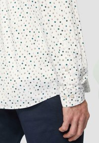 Witte shirt met een patroon van kleine groene en gouden cirkels, met knoopmanchetten en een gladde stofstructuur. Geschikt voor casual kleding.