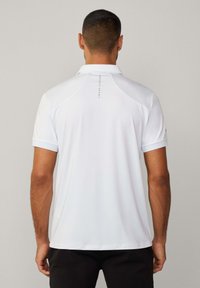 Weiße Poloshirt mit standardmäßigem Kragen, kurzen Ärmeln und einem vertikal auf dem Rücken aufgedruckten Logo. Hergestellt aus glattem, elastischem Stoff.