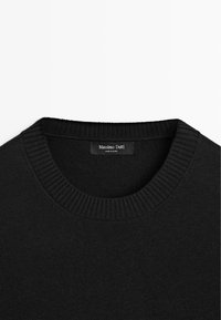 Czarny sweter dziany z okrągłym, prążkowanym kołnierzem. Posiada metkę z napisem 'Massimo Dutti'. Gładka faktura i prosty design.