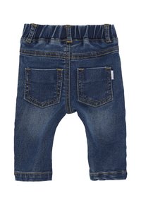 Tył ciemnoniebieskich jeansów dla małego dziecka z elastycznym pasem i dwoma przyszytymi kieszeniami z tyłu, na białym tle.