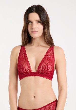 Bralette de encaje rojo con escote en V profundo, bordes con ondas y patrón floral. Material suave y translúcido con un acabado liso.