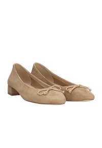Bailarinas de ante beige con un bajo tacón de madera, que presentan un lazo decorativo y un diseño de punta redondeada. Textura suave sin patrones visibles.