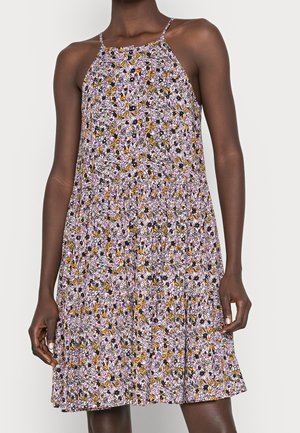 Robe sans manches avec fines bretelles et jupe évasée, présentant un motif floral dense en jaune, noir, blanc et lavande.