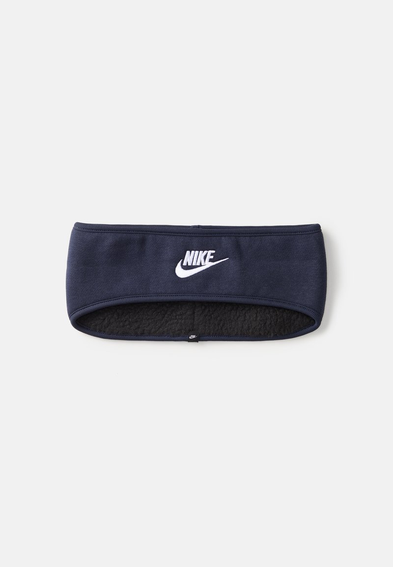 Temno modra športna traku Nike z mehkim, flisastim notranjim slojem. Ima izrazit bel Nike logotip spredaj. Gladka tekstura, elastična prileganje.