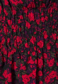 Abito floreale con motivi di rose rosse e viola su sfondo nero; presenta una texture arricciata con dettagli di smocking elastico.