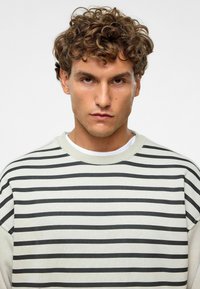 Gestreepte sweatshirt met een ronde hals, met horizontale zwart-witte strepen, zachte stof en verlaagde schouders.