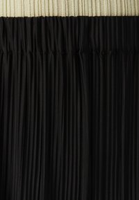 Black pleated skirt with a gathered waistband. The fabric features subtle sheen, creating depth through its vertical texture and lines.