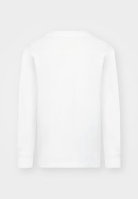 Valkoinen pitkähihainen paita, jossa pyöreä pääntie, valmistettu pehmeästä kankaasta. Päällä sileä pinta ja suoraviivaisesti leikatut hihat. Yksinkertainen muotoilu, näkyviä logoja ei ole.