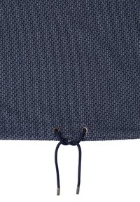 Marineblauest Gewebe mit einem strukturierten Muster, das am unteren Rand einen Kordelzug mit metallenen Ösen und Spitzen aufweist. Weiche, gewebte Textur im gesamten Material.