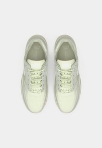 Αθλητικά παπούτσια ανοιχτού πράσινου χρώματος με υφή, στρογγυλεμένη μύτη και γκρι λεπτομέρειες. Διαθέτουν κορδόνια και μαλακή σόλα. Ορατό το λογότυπο της Nike.