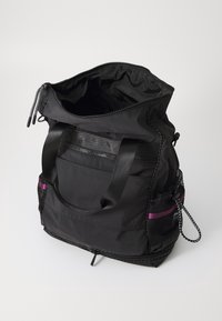 Musta nailontavarakassi, jossa on kaksi tukevaa kahvaa, vetoketjullinen suljenta, sivulla verkkotasku ja violetteja yksityiskohtia. Kuvioitu pinta ja jämäkkä muoto.