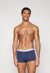 Marineblaue Shorts mit einem hellgrauen Bund, aus weichem Stoff gefertigt, mit einer engen Passform und leichtem Stretch für zusätzlichen Komfort.
