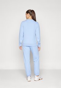 Sweatshirt bleu clair et joggings assortis en tissu doux, avec des poignets et des ourlets en côte, une taille élastique et des poches latérales.