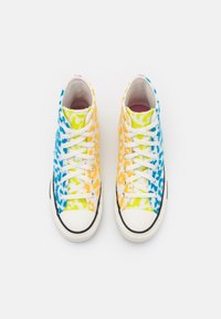 High-top sneakers featuring a tie-dye pattern in blue, yellow, and orange, with white laces, rubber toe cap, and black sole.