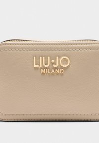 Beżowy skórzany portfel z złotym logo "LIU·JO MILANO", z suwakiem i teksturowanym wykończeniem. Posiada kontrastowe szwy. Kompaktowy prostokątny kształt.