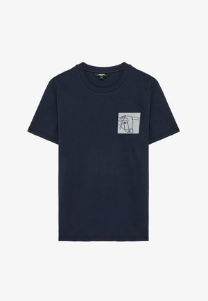 T-shirt bleu marine à manches courtes avec une petite poche gris clair sur la poitrine gauche, ornée d'un dessin abstrait noir d'une tête de taureau.
