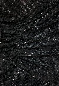 Tessuto a rete nera con un design arricciato, caratterizzato da paillettes lucide che creano una superficie testurizzata che aggiunge interesse visivo.