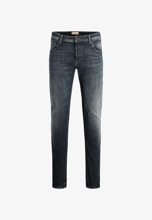 Tumed sinised denim püksid, kitsas lõige. Omavad viit taskut, lukuga esitasku, metallist nööp ja kerge kulumine reitel.
