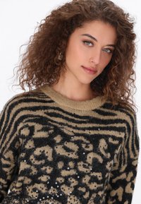Beige és fekete kötött pulóver leopárdmintás dizájnnal, textúrált felülettel és szórt flitterekkel a részletek fokozásáért.