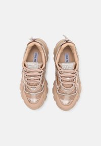 Beiga och metalliska sneakers med ovandel i mesh och läder, kraftiga gummisulor och dekorativa strassdetaljer på snörena.