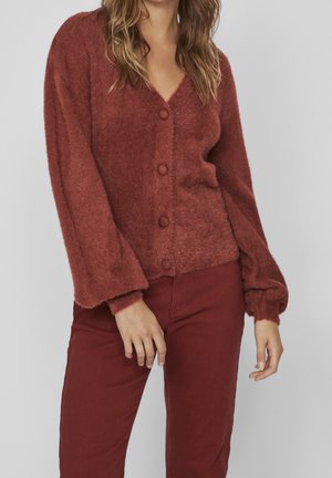 Roestkleurige, fluffy cardigan met een V-hals, lange mouwen en vijf knoopsluitingen. Heeft ribgebreide manchetten en een iets losse pasvorm.