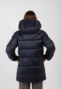 Giacca puffa blu marina con un grande cappuccio imbottito, design a trapunte orizzontali e taglio di lunghezza media, caratterizzata da una consistenza lucida e liscia.