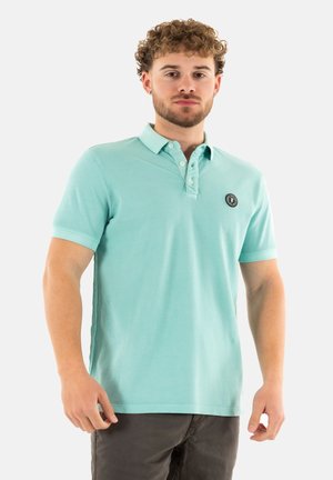 Polo shirt bleu clair à manches courtes avec un col boutonné et un patch logo sur le côté gauche. Fabriqué en tissu de coton doux.