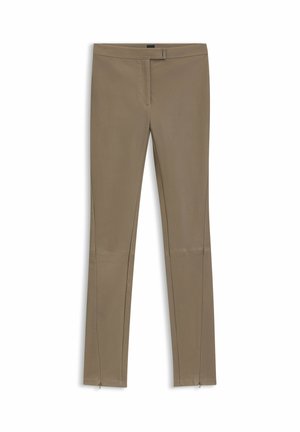 Beige leggings, joissa on kapea malli, sujuva pinta, vetoketjulliset nilkkasadat ja keskimittainen vyötärö.