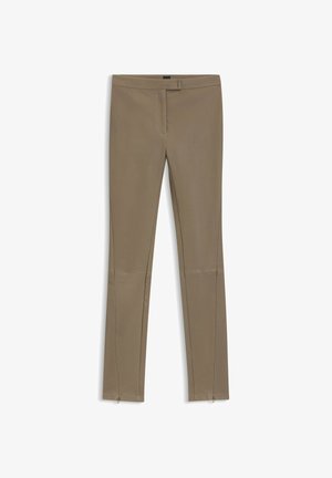 Beige stretch pants with a slim fit, featuring a smooth texture, zippered ankle details, and a mid-rise waistband.