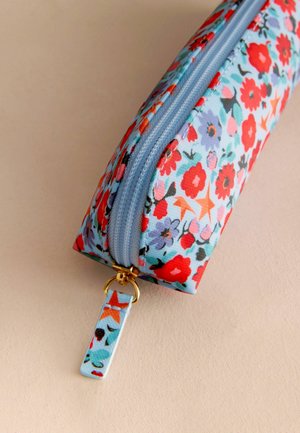 Kosmetyczka w kwiaty na niebieskim tle, z czerwonymi i purpurowymi kwiatami, złotym zamkiem i materiałową pętlą w dopasowanym wzorze.