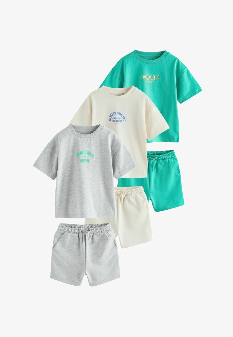 Trois ensembles de T-shirts à manches courtes et shorts à taille élastique pour enfants en gris, crème et turquoise avec un texte imprimé sur les chemises.