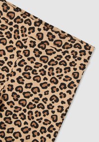 Tessuto in stampa leopardata con motivi a forma di cuore in nero e marrone chiaro su sfondo beige. Texture liscia, bordo piegato visibile.
