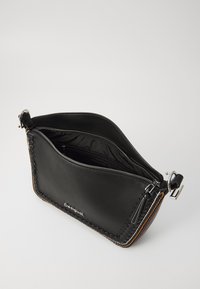 Borsa a mano in pelle nera con chiusura a zip, dotata di un dettaglio in tessuto intrecciato sul lato e un logo impresso sul davanti.