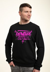 Sudadera negra con un audaz diseño gráfico en color rosa que dice "Los Ángeles, California" y acentos numéricos. Tela suave y casual.