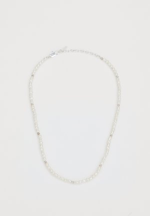 Collana di perle con perle bianche irregolari intervallate da piccoli dettagli metallici. Chiusura sicura e catena regolabile.