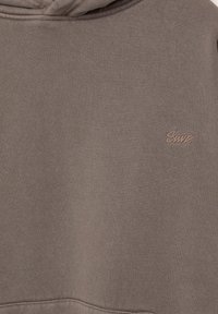 Sweat à capuche marron en tissu doux ; doté d'une capuche à cordon de serrage et d'un petit logo brodé sur le côté gauche.