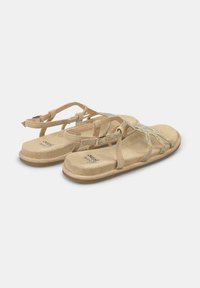 Sandali in suede beige con suola piatta, design incrociato con dettagli luccicanti e cinturino regolabile per una vestibilità sicura.
