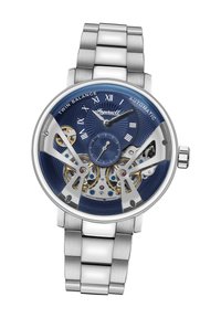 Roestvrijstalen automatische horloge met een blauwe wijzerplaat, zichtbare uurwerken en zilveren accenten. Voorzien van Romeinse cijfers en een gestructureerde wijzerplaat.