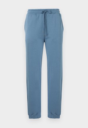 Světle modré teplákové kalhoty z měkké látky, s elastickým pasem se stahovací šňůrkou, bočními kapsami a elastickými manžetami u kotníků.