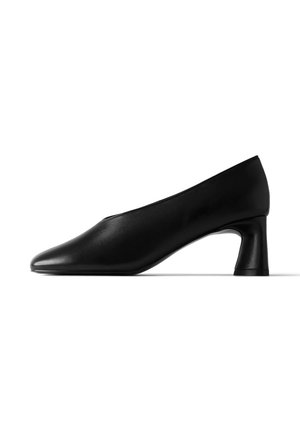 Chaussure basse en cuir noir avec bout arrondi et talon bloc, vue de côté sur fond blanc.