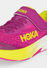 Φουξ και κίτρινο παπούτσι τρεξίματος Hoka με κορδόνια και λουρί βέλκρο, με ανθεκτικό αεριζόμενο πλέγμα και παχύ μαλακό πέλμα.