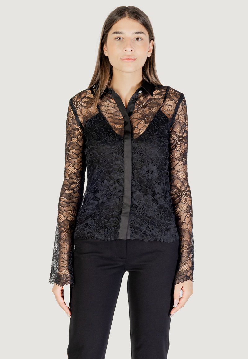 Camicia in pizzo nero con un motivo floreale trasparente, maniche lunghe, colletto e chiusura frontale con bottoni in satin.