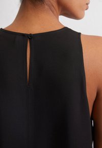 Top senza maniche nero con chiusura a bottone sul retro, presenta un design a occhiello e una texture liscia e opaca.