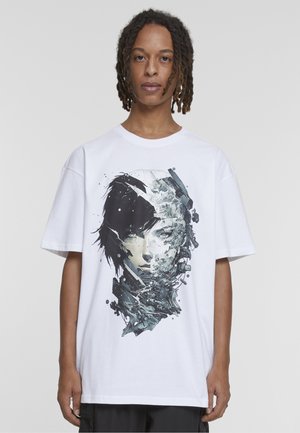 Jeune personne avec des dreadlocks portant un T-shirt blanc avec un visage cybernétique fragmenté en noir et blanc.