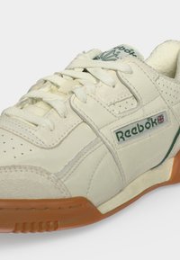 Παπούτσι Reebok εκρού με πράσινο λογότυπο, σημαία Union Jack, επενδυμένο κολάρο και λαστιχένια σόλα, από το πλάι και μπροστά.